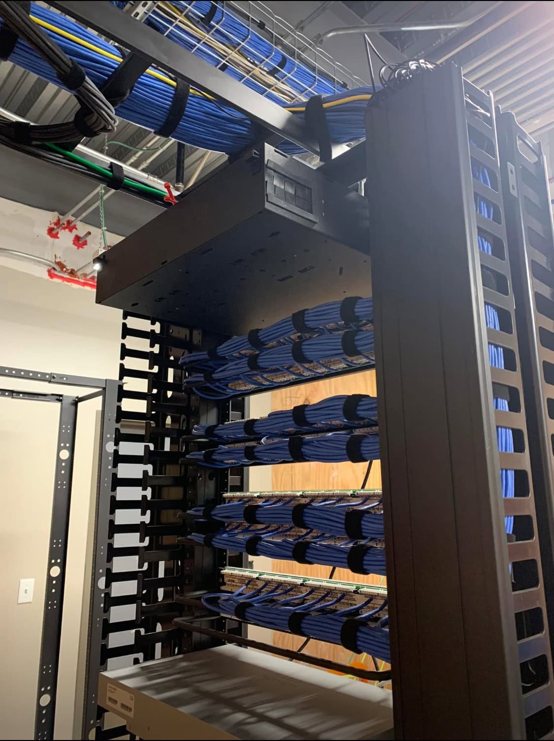 Structured cabling installation with organized blue cables for a multi-floor office network