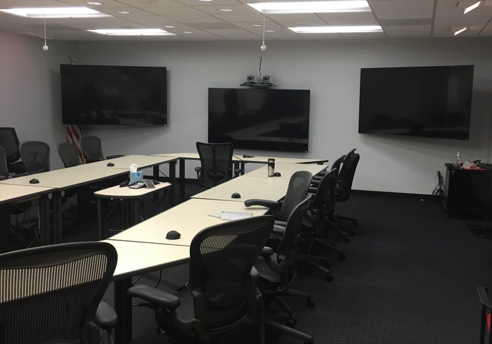 Conference room AV installation for a hybrid meeting room with multiple displays and seating