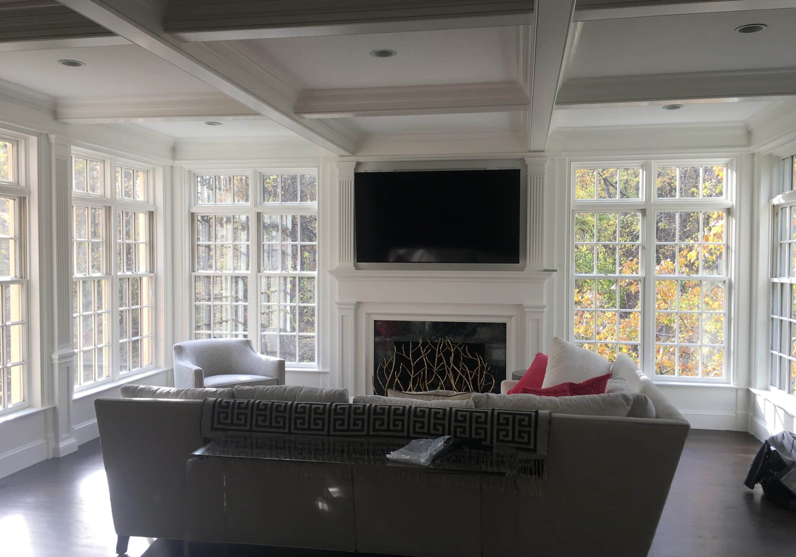 Home audio video installation for a family media room with wall-mounted TV and hidden speakers